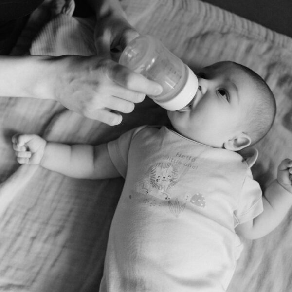 baby drinking milk out of a bottle